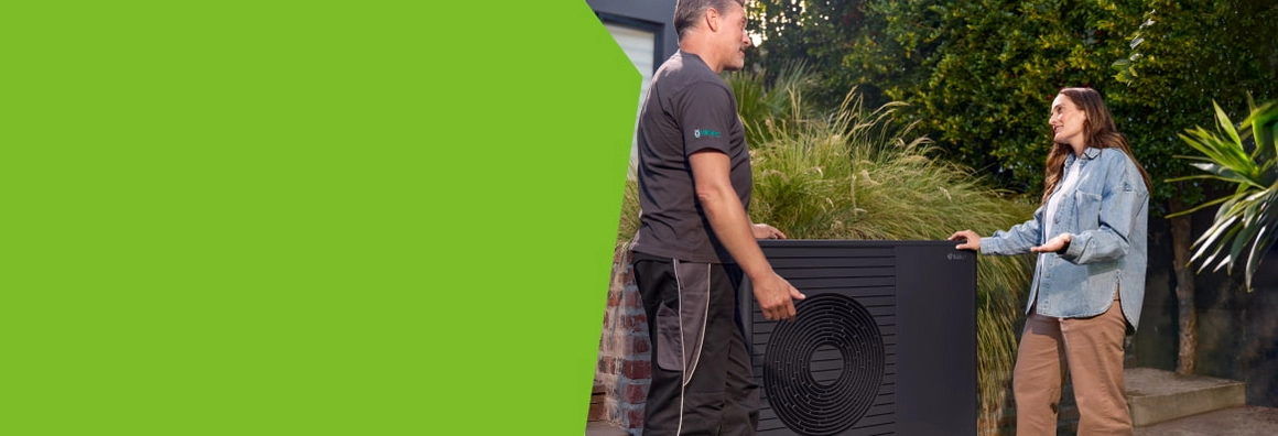 Zwei Personen besprechen die Installation einer Wärmepumpe im Garten.